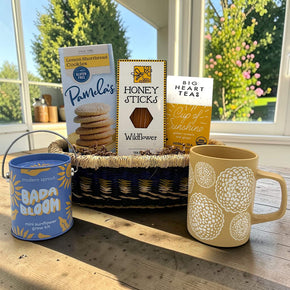 Handwoven tray with cookies, tea, honey, a mug, and a plant grow kit