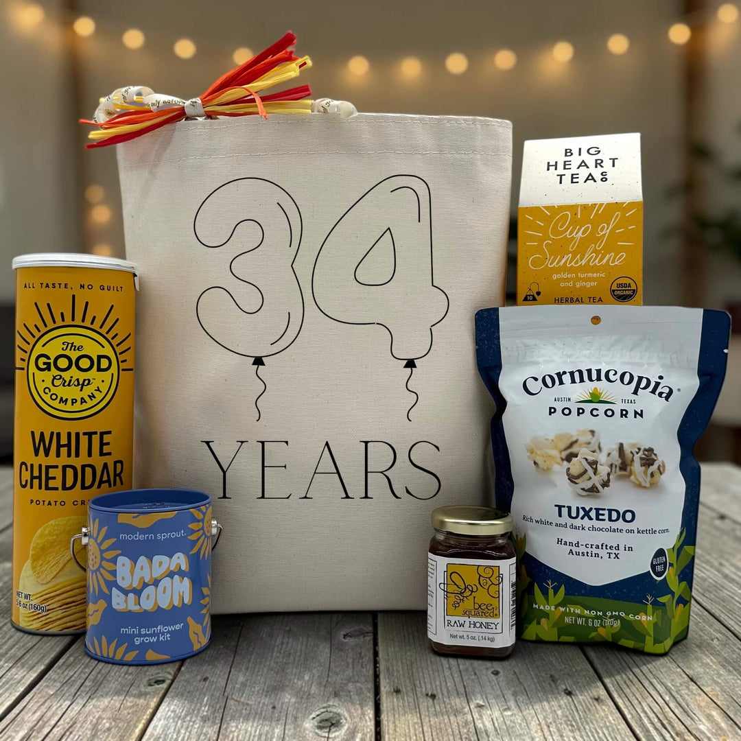 Gourmet anniversary gift basket with white cheddar chips, a sunflower grow hit, honey, tea and popcorn