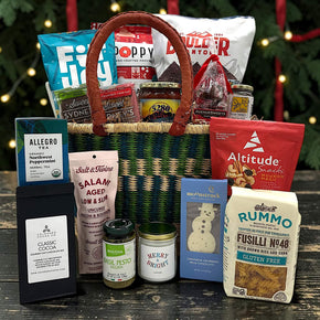 Gourmet holiday gift basket with pretzels, popcorn, chips, cookies, salsa, caramels, tea, cocoa, candle, pasta, pesto, and more