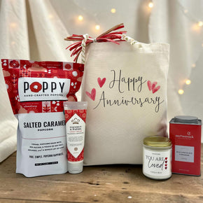 heartfelt anniversary gift basket with salted caramel popcorn, lotion, a you are loved candle and cocoa