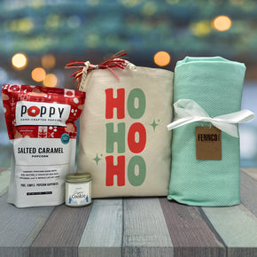 gourmet holiday gift basket with popcorn, a candle and a blanket