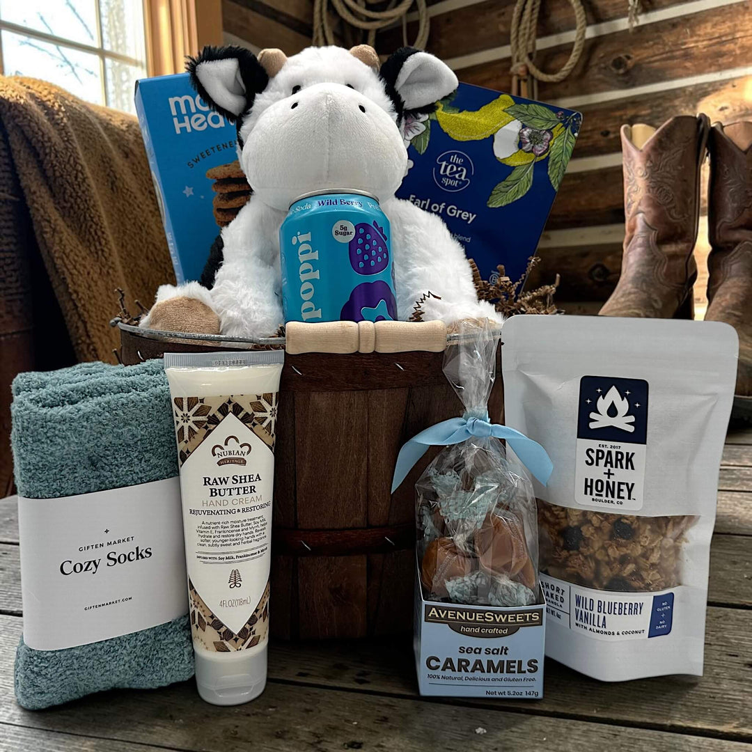 Gourmet baby boy gift basket with cookies, tea, a stuffed cow, poppi, socks, lotion, caramels and granola