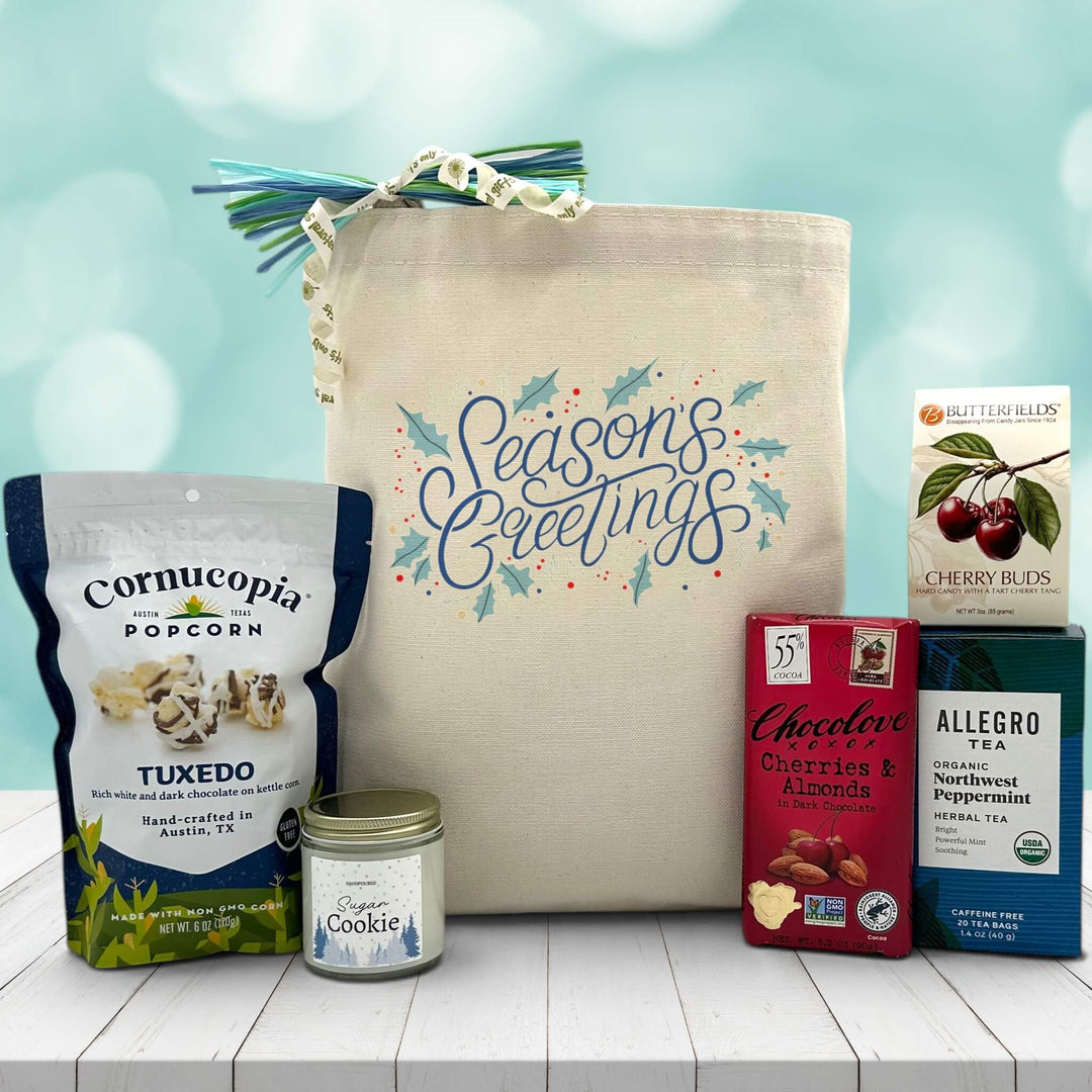 Gourmet gift basket with popcorn, a candle, chocolate bar, tea, and cherry buds