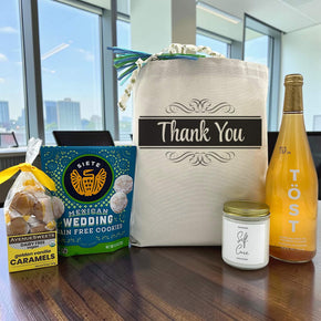 Gourmet thank you gift basket with caramels, cookies, a large candle and sparkling juice