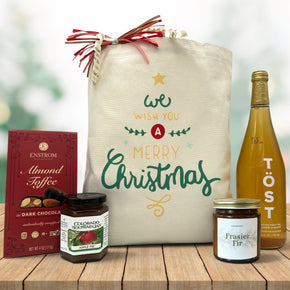 Gourmet christmas gift basket with almond toffee, jam, a candle and sparkling juice
