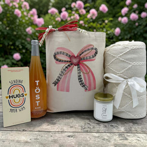loving gift with a chocolate bar, sparkling juice, a large candle and a white knit blanket