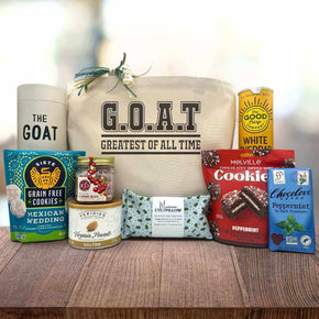 Gourmet holiday gift basket with a drinking glass, cookies, peanuts, cherry buds, an eye pillow, cookies, chips and chocolate