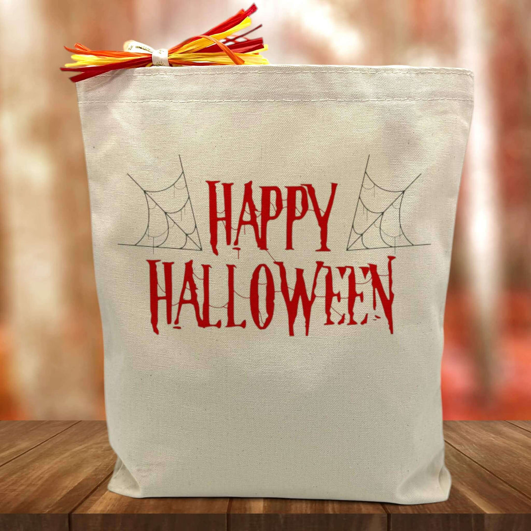 Happy Halloween in red printed on a canvas tote bag sitting on a table