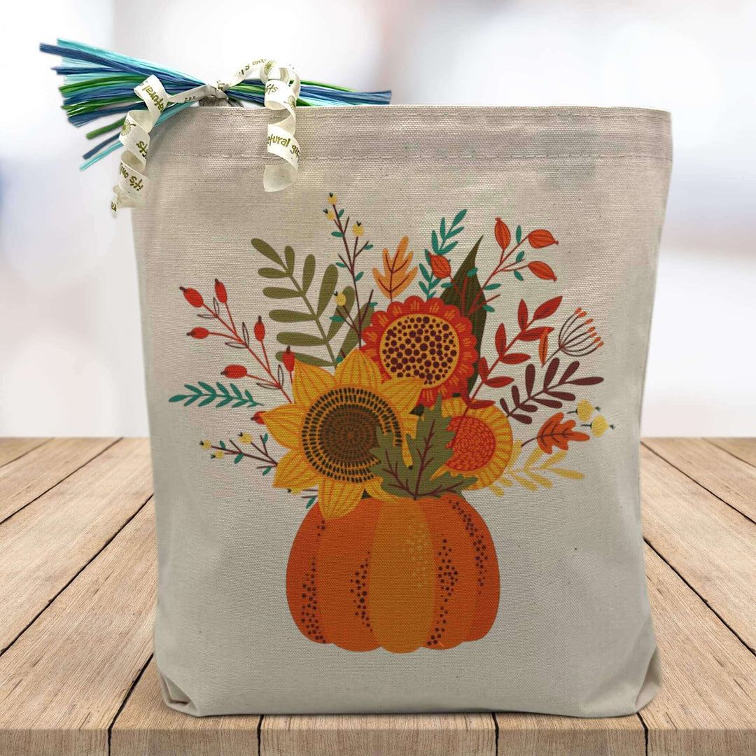 pumpkin floral bouquet printed on a canvas tote bag sitting on a table with a blurred white background