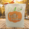 orange pumpking with hello pumpking script inside printed on a canvas tote bag sitting on a table