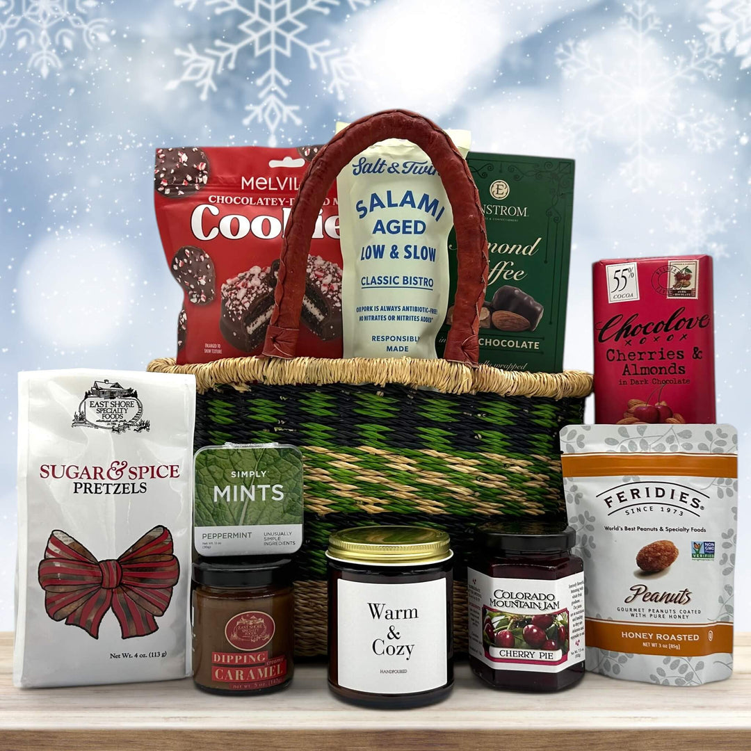 Gourmet holiday handwoven basket with cookies, salami, almond toffee, pretzels with caramel, mints, a large candle, jam, peanuts and a chocolate bar