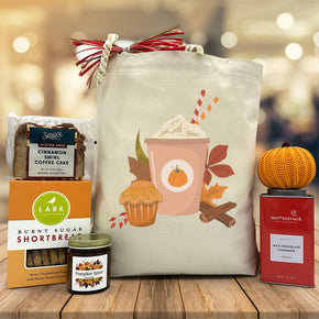 Gourmet Fall gift basket with bread, cookies, a candle, cocoa and a knit pumpkin sitting on a table