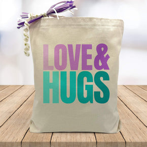 love in purple and hugs and blue  printed on canvas tote bag sitting on table with white blurred background