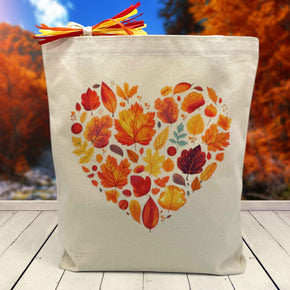 fall leaves themed heart printed on a canvas tote bag sitting on a table with a blurred fall background