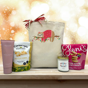 Holiday gift basket with lotion, popcorn, a large candle and cookies