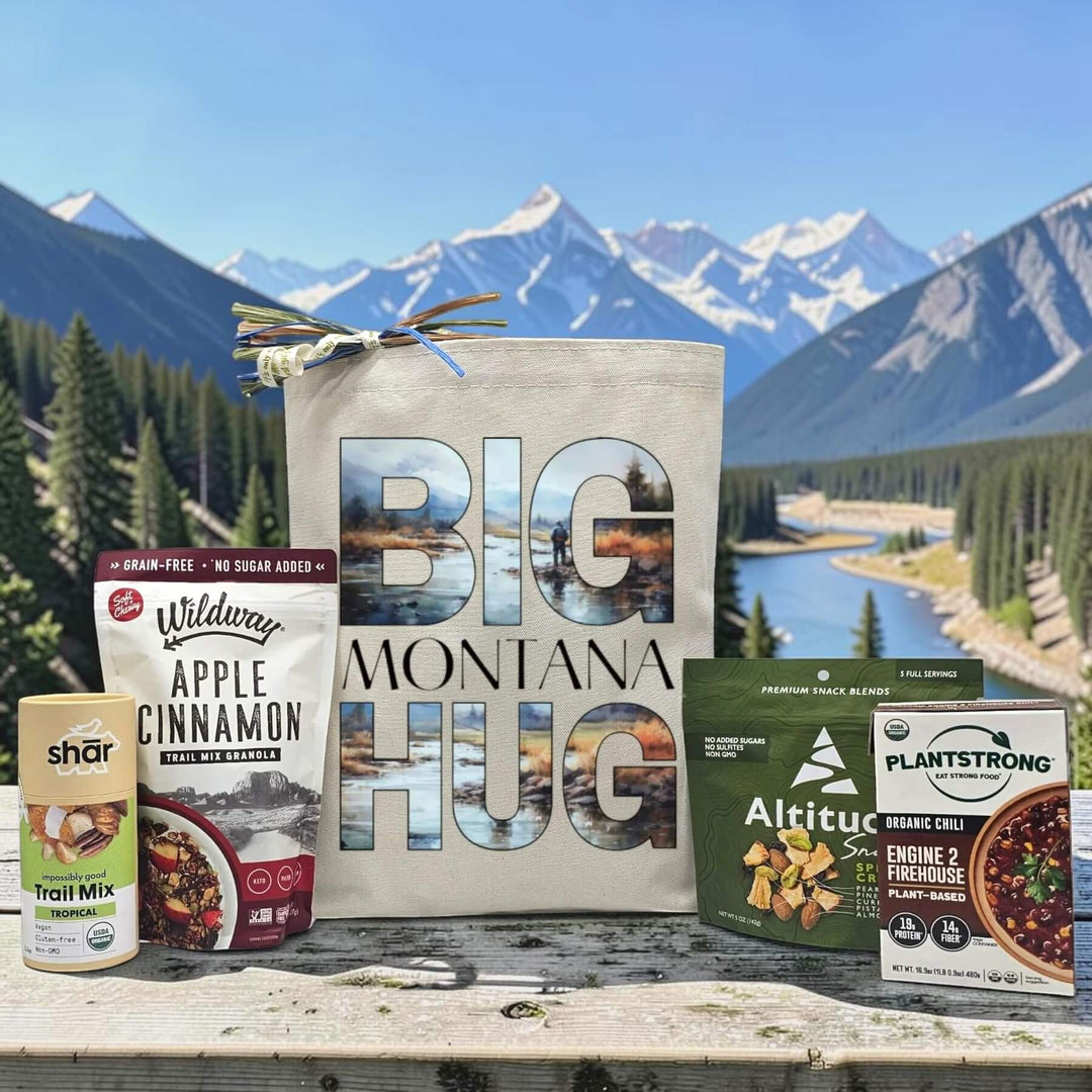 Big Montana hug printed on canvas tote bag with trail mix, granola, and chili with a montana scene in the background
