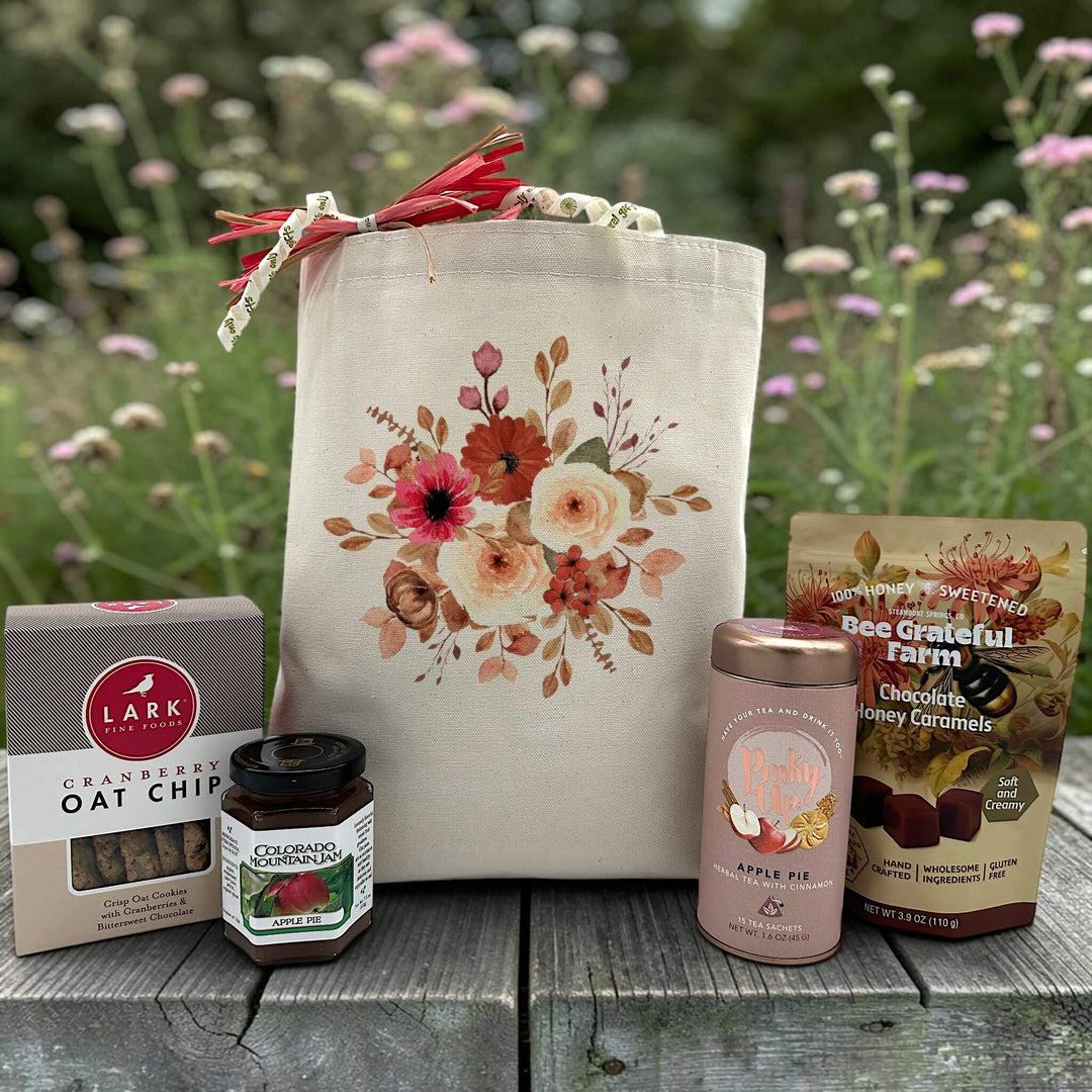 Floral gift basket with cookies, jam, tea, and caramels