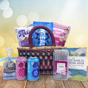 colorful medium african market basket filled with refreshing snacks and drinks siting on a table