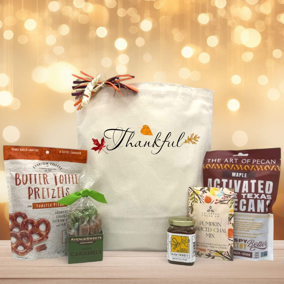 Thankful script basket with pretzels, cramels, honey, pumpkin spice chai, and pecans sitting on a table