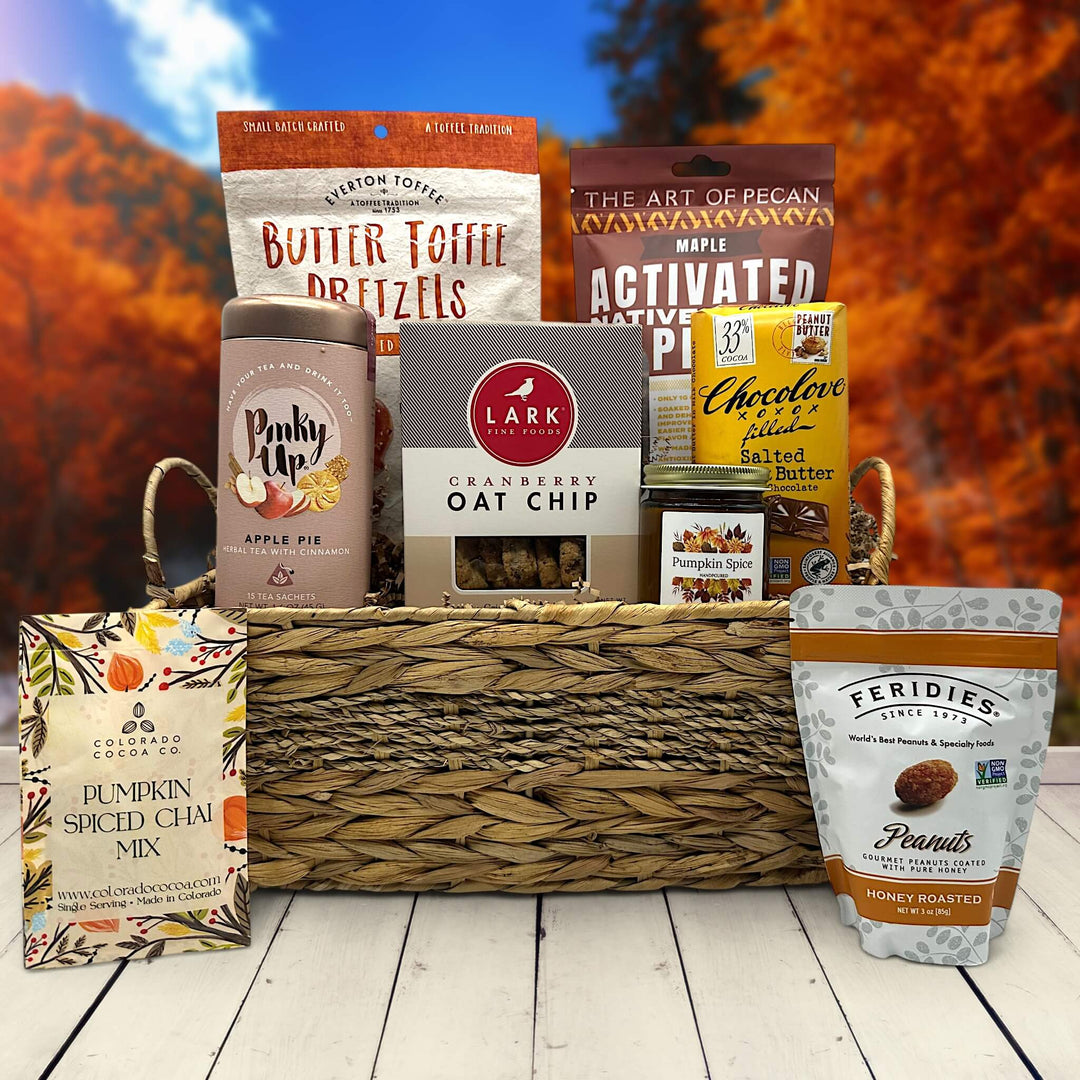 wicker basket with pretzels, pecans, tea, cookies, candle, chocolate, pumpkin spice chai and eanuts
