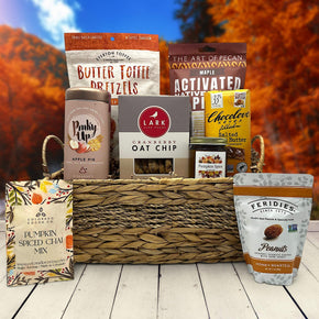wicker basket with pretzels, pecans, tea, cookies, candle, chocolate, pumpkin spice chai and eanuts