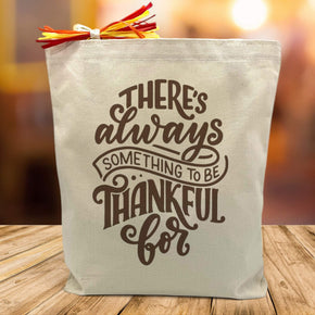theres always something to be thankful for printed on a canvas tote bag sitting on a table