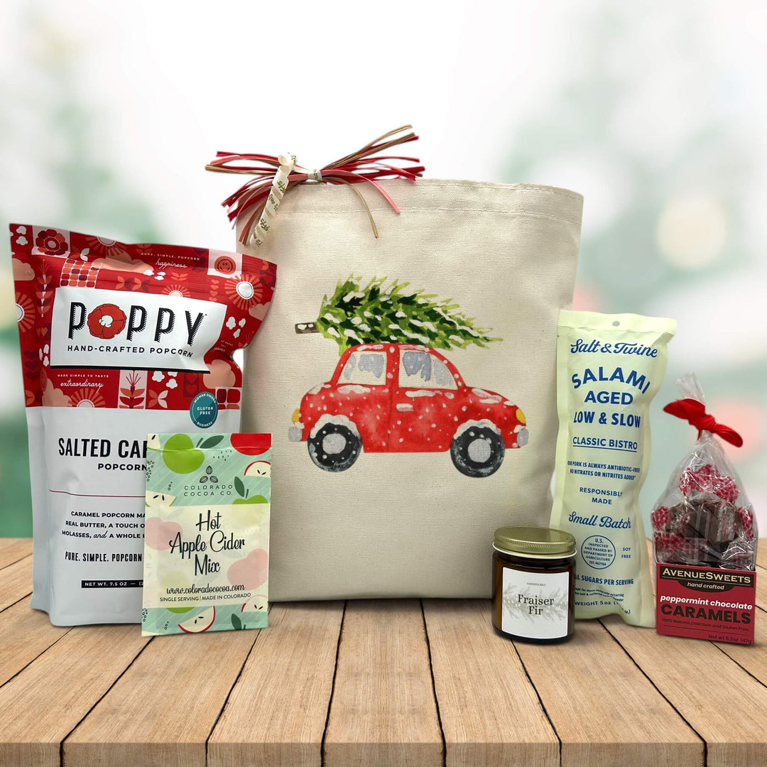 Gourmet holiday gift basket with salted caramel popcorn, apple cider mix, frasier fir candle, salami, and peppermint caramels