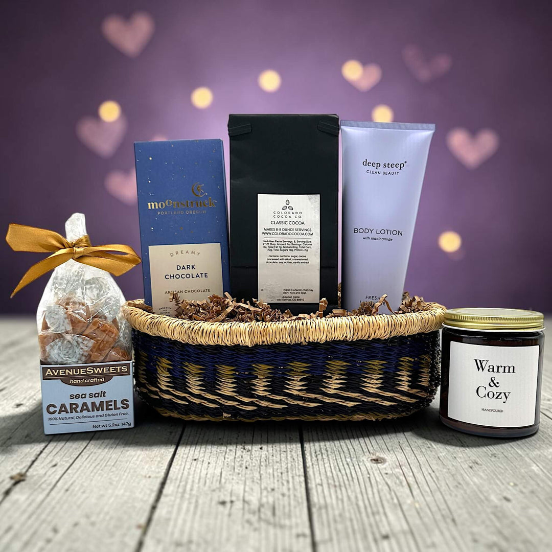 handwoven tray with caramels, chocolate bar, cocoa, lotion and a large candle