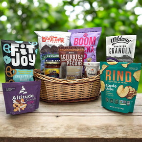 wicker basket with chips, popcorn, pretzels, granola, apple chips, pecans, oatmeal and more vegan snacks