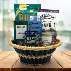 handwoven tray with apple chips, granola, chocolate bar, tea, a plant grow kit and a candle