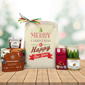 gourmet holiday and new year basket with oatmeal, tea, chocolate bar, peanuts, and a mug