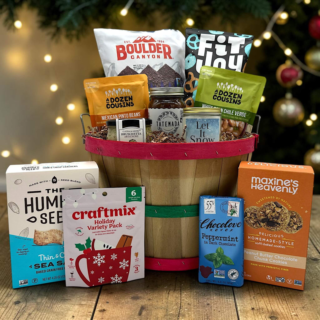 Gourmet holiday gift basket with chips, pretzels, chili, salsa, a large candle, crackers, chocolate, cookies and more