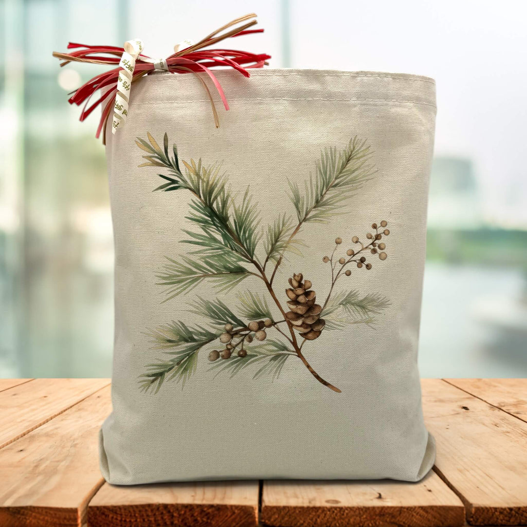 Frasier fir and pine cone printed on a canvas tote bag sitting on a table with blurred green background